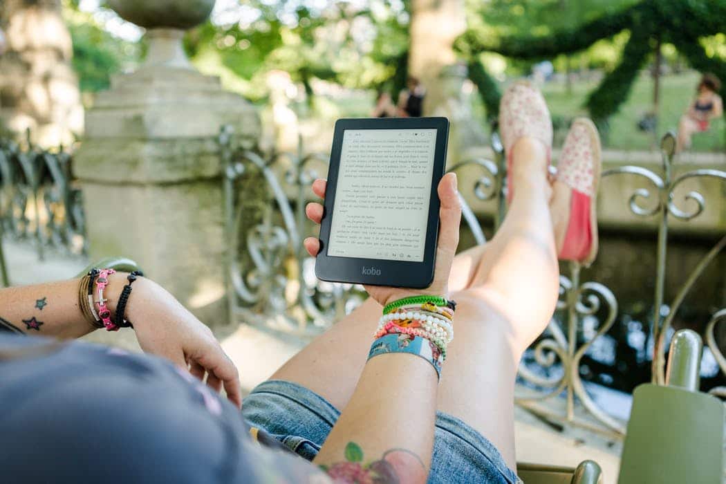 Woman reading a Kobo eReader on holiday feature image for blog