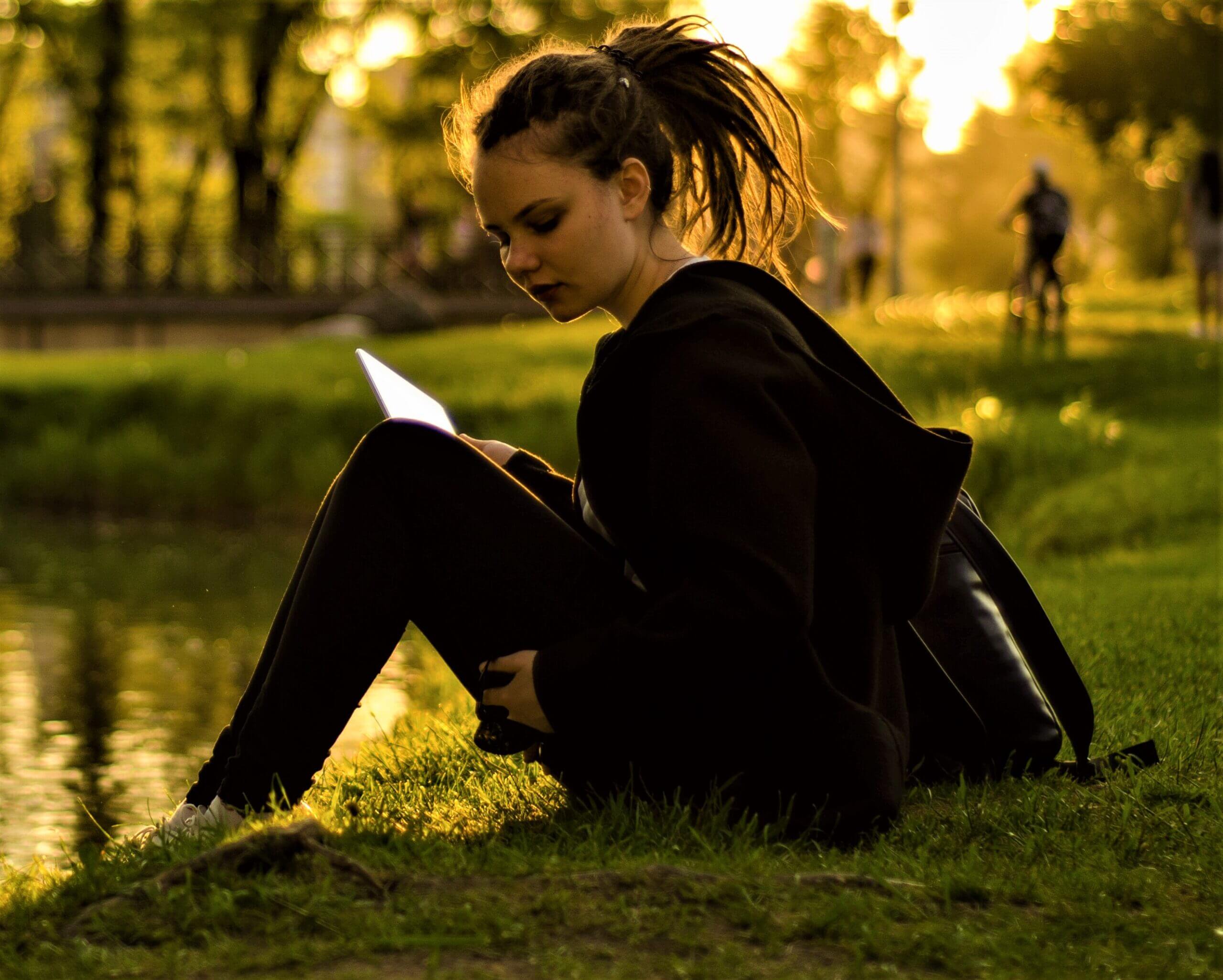 teen reading by water scaled