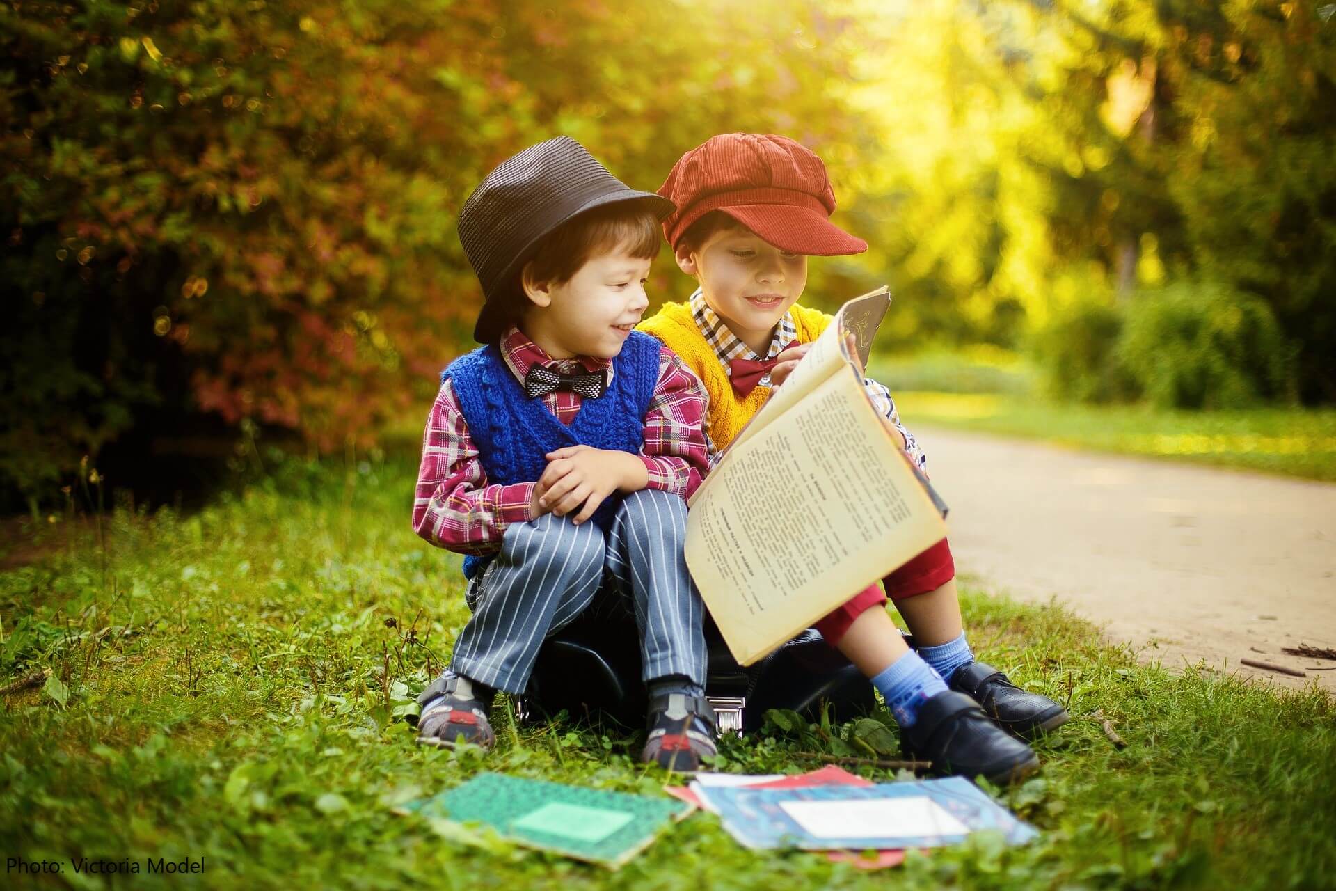 2 kids reading outside