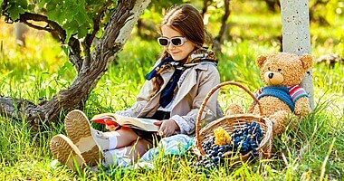 kid reading a book outdoors